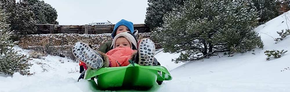 kingsley and aurora sledding in the snow
