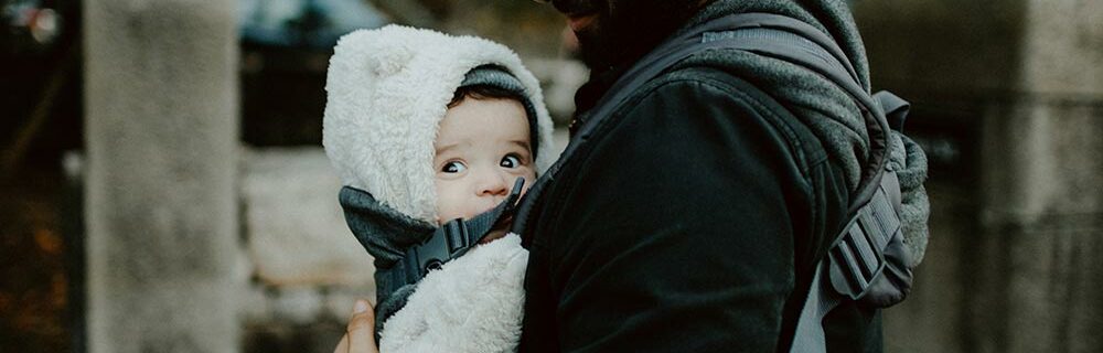 father using carrier to carry baby