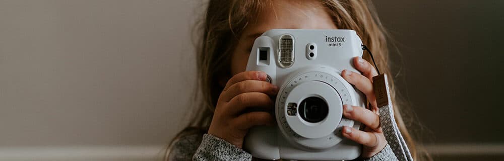 girl holding point and shoot camera