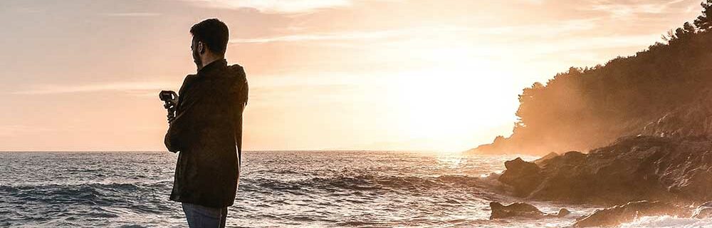 Man vlogging by the ocean