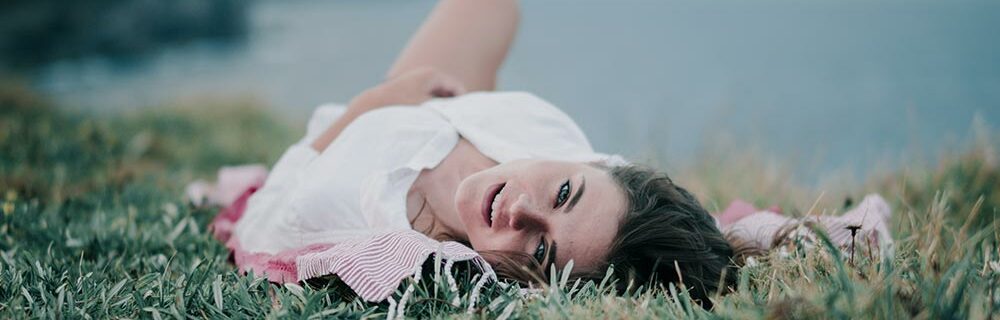 Woman laying on grass postpartum